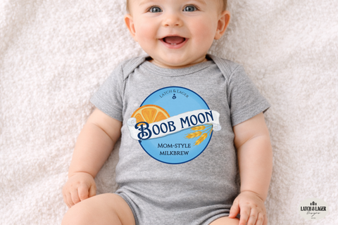 Baby wearing a gray onesie with 'Boob Moon' branding on a light background
