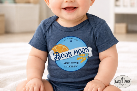 Baby wearing a blue onesie with 'Boob Moon' branding