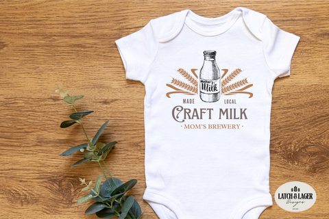 Baby onesie with 'Craft Milk' design on a wooden surface