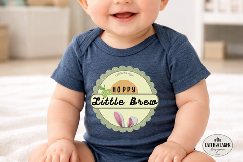 Baby wearing a blue onesie with 'Hoppy Little Brew' design, sitting on a white surface.