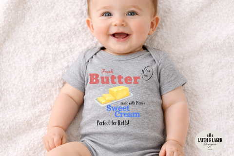 Baby wearing a gray onesie with text and a graphic of butter on a light gray background
