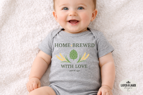 Baby wearing a gray onesie with 'Home Brewed with Love' text and graphics on a light background
