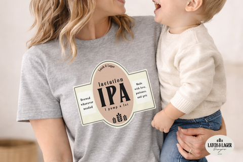 Woman wearing a t-shirt with 'Latch & Lager' branding, holding a child.