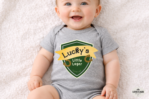 Baby wearing a gray onesie with 'Lucky's Little Lager' print on a light background