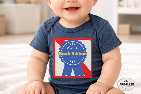 Baby wearing a navy blue onesie with a graphic design and text, sitting on a light-colored surface.