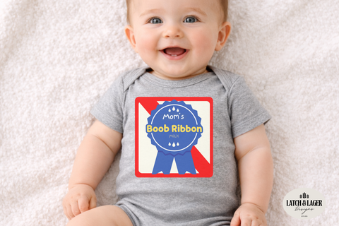 Baby wearing a gray onesie with a colorful graphic, sitting on a soft surface.
