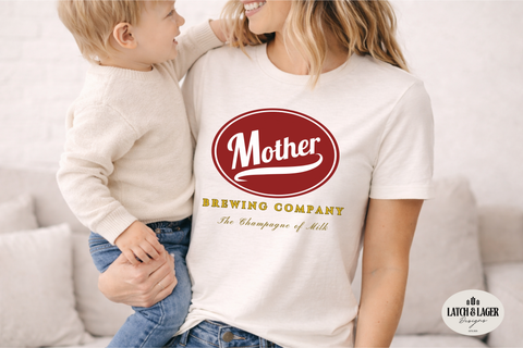 Woman wearing a 'Mother Brewing Company' t-shirt holding a child on a couch.