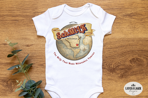 White baby onesie with a graphic design on a wooden surface