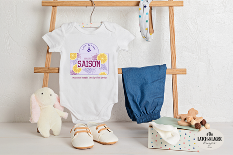 Baby clothing and accessories on a wooden rack against a white wall