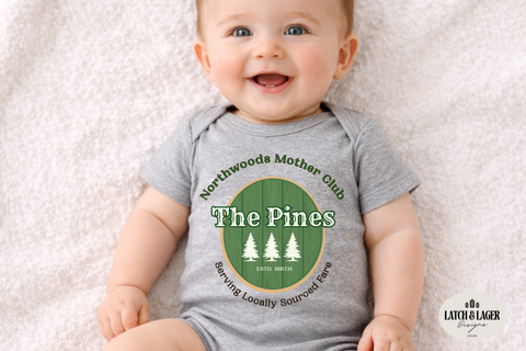 Baby wearing a gray onesie with 'The Pines' logo on a light background
