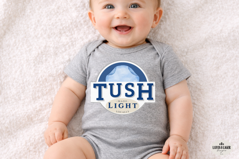 Baby wearing a gray onesie with 'TUSH the Light' logo on a light background